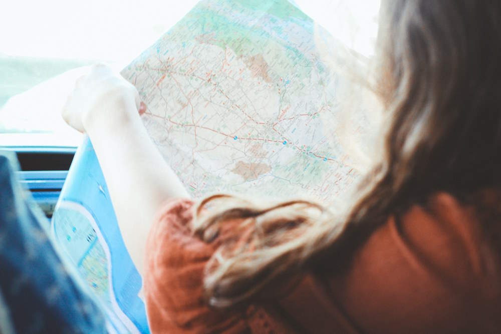 femme en train de lire une carte lors de son roadtrip